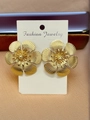 Macro view of gold flower earrings with embossed textures on a fashion jewelry card - Petal Shape Gold Stud Earrings