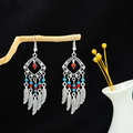 Détail de boucles d'oreilles bohèmes vintage avec perles turquoise et plumes en métal - Multicolore