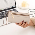 Detail of beige lychee leather long wallet with golden leaf zipper and wrist strap - Off White