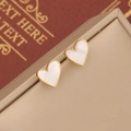 Elegant gold shell heart earrings displayed on a vintage book and beige jewelry box - Heart Mother of Pearl Earrings