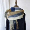Sciarpa classica a quadri blu e beige con lunghe frange su un manichino in legno - Blu Marrone