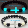 Bracciale croce in pietra vulcanica con luce blu chiaro vista giorno e notte - Bagliore Blu Chiaro