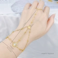 Gold star hand harness bracelet featuring round beads on elegant white satin background - Star