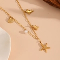 Close-up of golden necklace with dolphin, shell, turtle, starfish charms and a pearl - Starfish Zirconia Beach Necklace (T703)