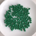 Macro shot of forest green cylindrical acrylic beads with glossy finish on a white plate - 10# Forest Green