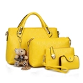 Detalle del juego de cuatro bolsos de mano en cuero repujado amarillo con grabados - Amarillo