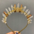 Detail of handmade crown with raw crystals and gold triple moon symbol being held - Orange White Patch Triple Moon