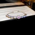 Detailed view of silver open bracelet with pink oval gemstone and sparkling white zircons - Bracelet - Silver