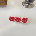 Close-up of triple cat head hair clips in red and cream resin finish for hair styling - Red