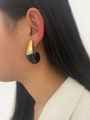 Close-up of 18K gold C-shaped earrings with black enamel detail on a fashion model - Black