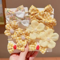 Handheld view of yellow bow hair clips and flower ties with floral lace detail - Yellow Radiant Style (0662-1)
