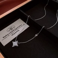 Macro detail of a silver star pendant with cubic zirconia on a luxury black gift box - Silver Cross Starburst / Silver