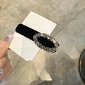 Nahaufnahme der eleganten schwarzen Samt-Haarklammer mit luxuriösem Strass-Oval-Dekor - Hohles Weidenblatt