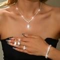 Close-up of elegant silver necklace, earrings, and bracelet set with white zircons - Four-Piece Set / Silver