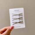 Three-piece set of silver X-shaped minimalist hair clips on a branded display card - Cross Design 3-Piece Set - 6CM