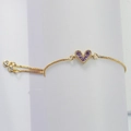 Dettaglio ravvicinato di un bracciale dorato a cuore con pietre di zirconia viola - Viola