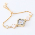 Detailed macro view of the gold clover charm bracelet watch with rhinestone bezel - Gold Clover White Dial