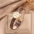 Macro shot of brown leather watch strap with gold crystal bezel and white shell dial - Brown