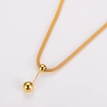 Detalle de la cadena dorada tejida con colgantes de doble esfera y borlas - Dorado