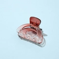 Macro shot of a red-brown transparent acetate hair claw clip on a light blue background - Semi-circular Red