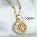 Golden Scorpio necklace featuring a micro-set zircon pendant on white silk background - Scorpio