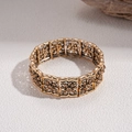 Detailed close-up of retro gold floral cutout bracelet with amber gemstone accents - Vintage Gold Hollow Floral Cuff Bracelet