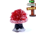 Macro detail of red crystal gemstone tree with black rock base on office desk - Red Glass