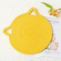 Vue macro d'un dessous de plat en coton tressé jaune en forme de chat avec oreilles - 18cm / Jaune Vif