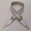 Close-up of adjustable beige shoulder strap with silver glitter stripes and gold hardware - Khaki Strap With White Leather