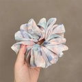 Chiffon tie-dye hair scrunchie in pink and blue cloud pattern held by hand - Tie-dye Blue