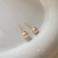 Close-up of minimalist pink pearl stud earrings with gold needles on white ceramic - 8mm Pearl (157#)