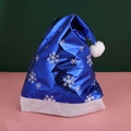 Metallic blue Santa hat with silver snowflakes and white plush trim on green background - Blue Metallic Fabric Snowflake Hat