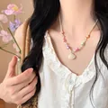Detail of seashell pendant necklace with colorful beads and beige woven rope on a model - 16# Necklace-White-Yellow