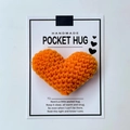 Handmade orange crocheted heart pocket hug on greeting card with warm sentiment - Orange