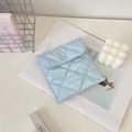 Dettaglio della borsa igienica trapuntata azzurra con bottone a cuore e ricamo - Azzurro