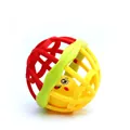 Gros plan sur la balle hochet pour bébé avec grille creuse et clochette à visage souriant - Rouge et Jaune