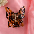 Close-up of tortoise shell butterfly hair clip on pink silk background with white flowers - 15# Tortoiseshell Cutout Butterfly Claw Clip