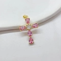 Detailed view of a gold-plated cross pendant with pink teardrop zircons on a white tray - Pink