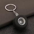 Macro detail of 3D car tire keychain showing realistic rubber treads and silver alloy rim - Antique Pewter