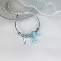 Silbernes gewebtes Stahlarmband mit blauem Bären und Herzanhängern auf einem Dekoteller - 4. sky blue bear
