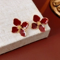 Close-up of red French flower stud earrings with golden edges on linen texture base - Gold Wine Red (Silver Earring Post)