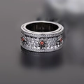 Macro view of a gunmetal gear ring featuring red stones and white zircon stones pavé - Silver with Red Stone