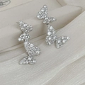 Detail showing silver butterfly earrings with sparkling crystals on white silk - Silver (Silver Pin) / Silver
