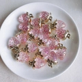 Detalle de colgantes de fresa de resina rosa con hojas doradas en un plato de cerámica blanca - 4# Rosa Con Burbujas