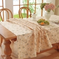 Detail of beige cotton linen tablecloth with white floral pattern on a wood table - Creamy Yellow Floral Print - Rolled Edges / 60*60cm