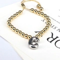 Detail of gold beaded bracelet featuring a silver letter C charm and adjustable slide clasp - Letter C