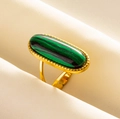 Makroansicht von Vintage-Goldring mit grünem Malachitstein auf Seidenstoff - Gold-Malachit-Muster
