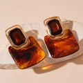 Macro detail of amber resin earrings with gold metal frame on a textured stone base - Amber Textured Square / Coffee (Silver Earring Post)