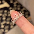 Macro shot of a luxury silver crown ring with sparkling pink heart stone and white zircon - Pink Diamond Crown
