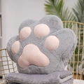Gray cat paw plush cushion with pink pads and matching blanket on a gold chair - Gray